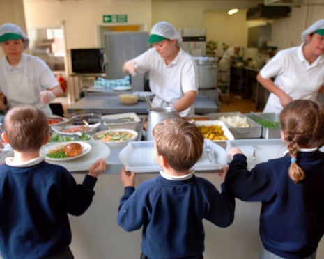 Children wait to be served dinner at a school in Swindon.