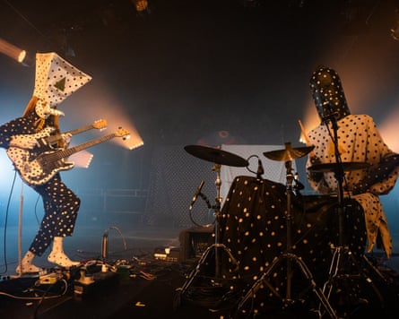 Musicians wearing masks perform on stage