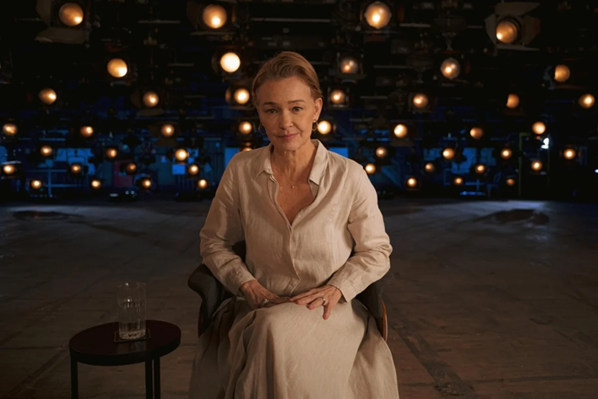 Imagem colorida da atriz Julia Lemmertz sentada em uma cadeira no meio de um palco de teatro - Metrópoles
