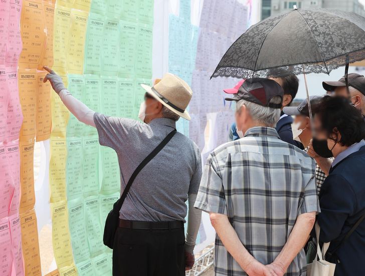 Senior citizens look at a job board during the 11th Suwon City Senior Citizens Job Fair in Suwon, June 21, 2022. Yonhap