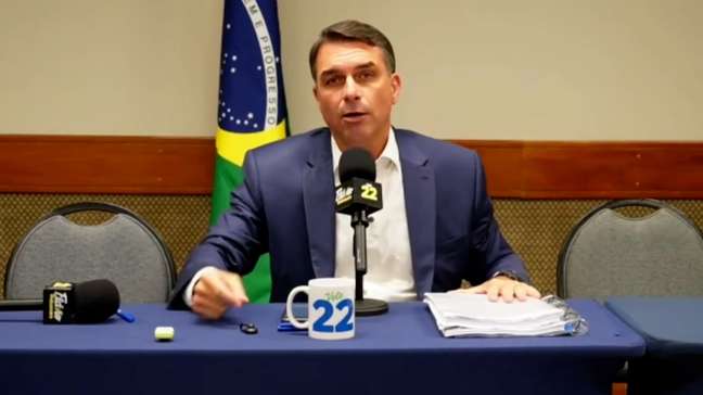 Após debate cancelado, Flávio Bolsonaro culpa Lula por 'interferência judicial', improvisa live com aliados e faz campanha por voto útil